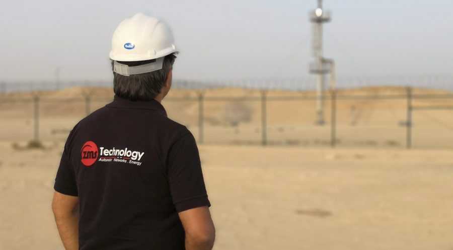 Field engineer at an oil and gas site with a gas flare in the background